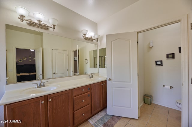 bathroom with tile patterned flooring, vanity, toilet, and vaulted ceiling