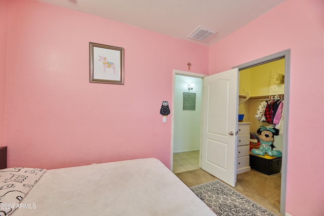 carpeted bedroom with a spacious closet and a closet