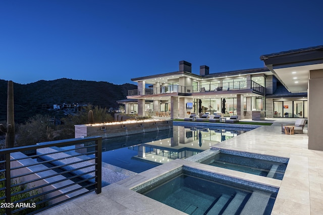 view of pool with a mountain view, a patio area, and an in ground hot tub