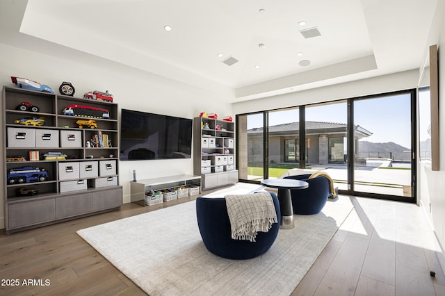 living room featuring hardwood / wood-style flooring and a raised ceiling