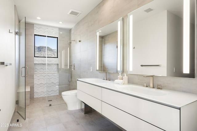 bathroom with vanity, tile walls, an enclosed shower, and toilet