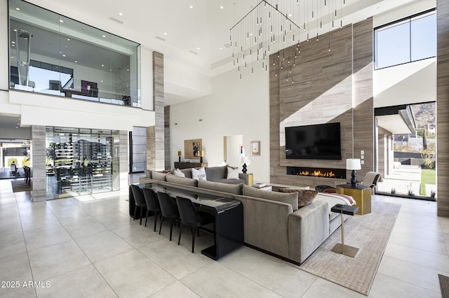 tiled living room with a towering ceiling and a fireplace