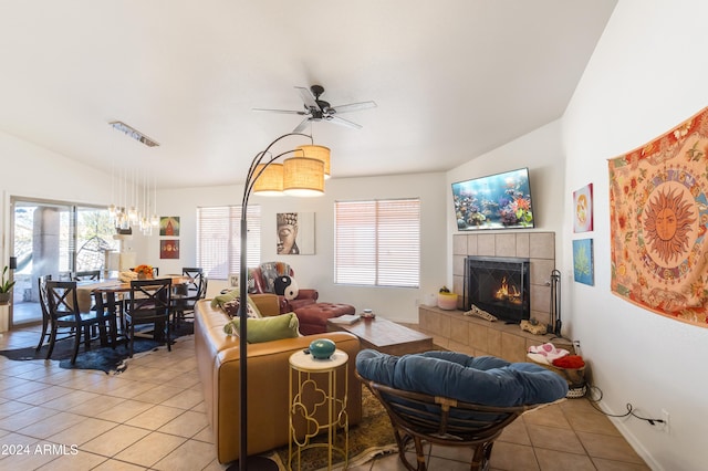 living room featuring a fireplace, light tile patterned floors, ceiling fan, and lofted ceiling