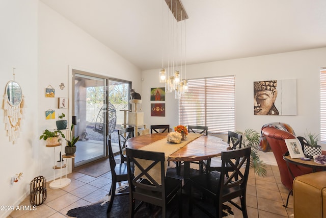 tiled dining space with a notable chandelier and lofted ceiling