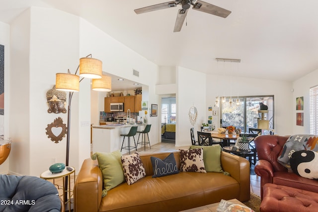 living room featuring ceiling fan, light tile patterned floors, a healthy amount of sunlight, and lofted ceiling