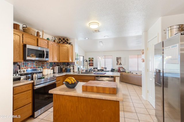 kitchen with lofted ceiling, sink, tasteful backsplash, light tile patterned flooring, and stainless steel appliances