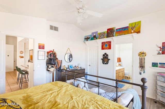 bedroom with hardwood / wood-style floors, ensuite bathroom, ceiling fan, and lofted ceiling