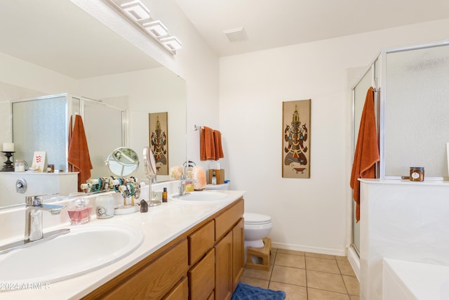 bathroom featuring tile patterned floors, toilet, vanity, and walk in shower