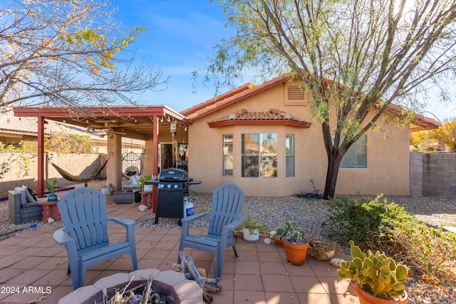 rear view of property with a patio area and an outdoor fire pit