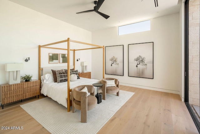 bedroom with radiator heating unit, ceiling fan, and light hardwood / wood-style flooring