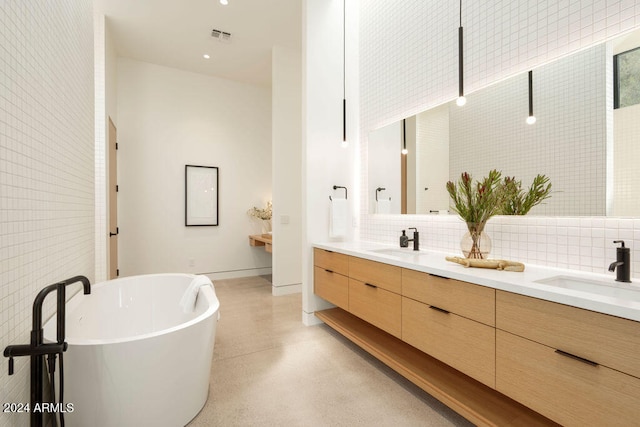 bathroom with decorative backsplash, concrete flooring, vanity, and a tub