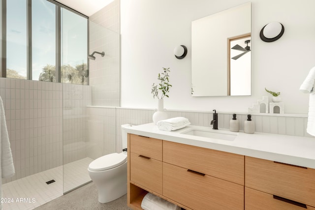 bathroom featuring vanity, toilet, and tiled shower