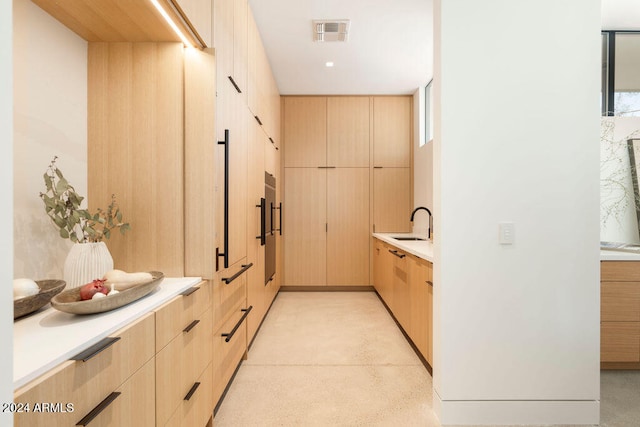 interior space with light brown cabinets, sink, and plenty of natural light