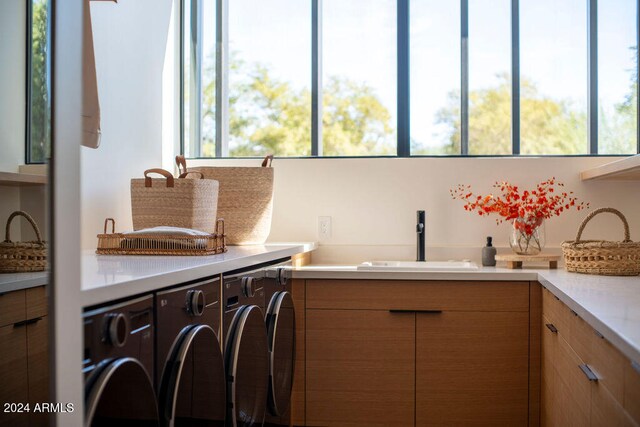 laundry area with cabinets, plenty of natural light, sink, and washer and dryer