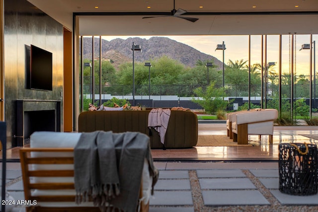 interior space with exterior fireplace, a mountain view, and ceiling fan