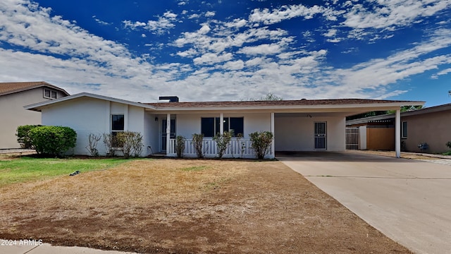 single story home with a porch, a front yard, and a carport