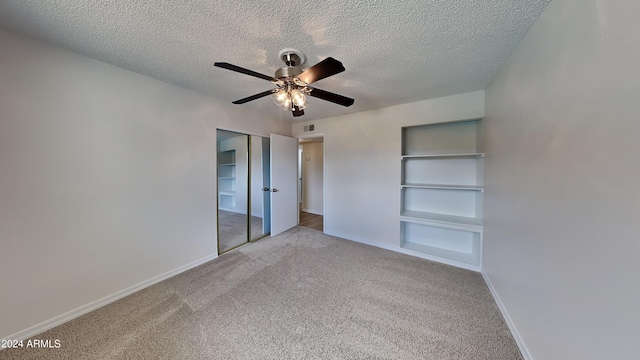 unfurnished bedroom featuring ceiling fan, light carpet, a closet, and a textured ceiling