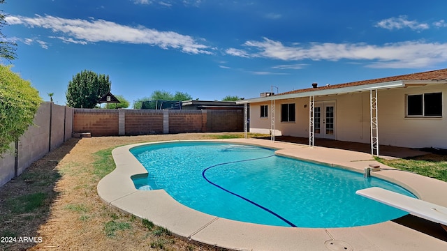 view of pool featuring a diving board, french doors, and a patio area