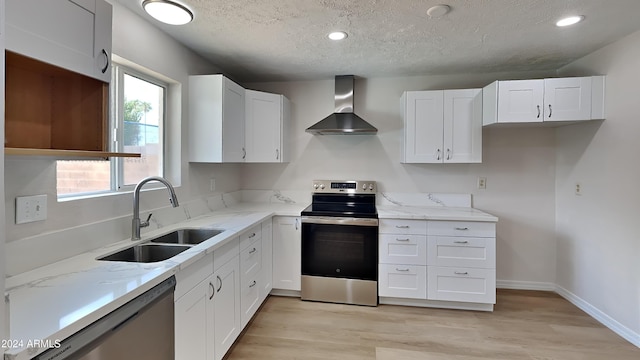 kitchen with white cabinetry, stainless steel appliances, wall chimney exhaust hood, and sink