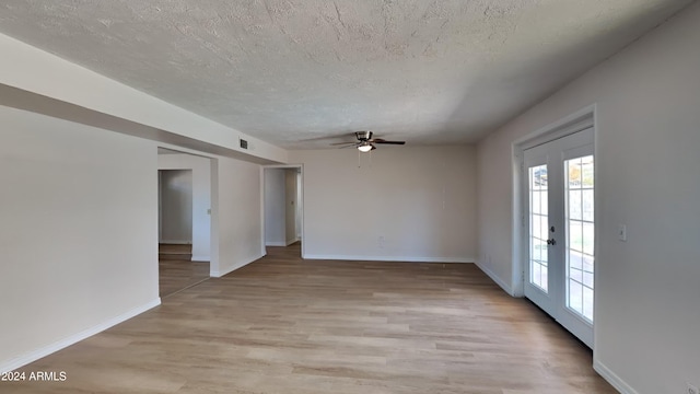 spare room with a textured ceiling, french doors, ceiling fan, and light hardwood / wood-style flooring