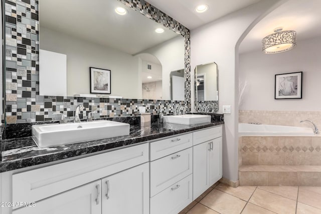 bathroom featuring tile patterned floors, tiled tub, and vanity