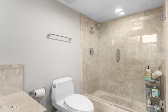 bathroom with a shower with door and toilet