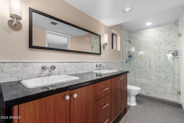 bathroom featuring tile patterned floors, walk in shower, vanity, tile walls, and toilet