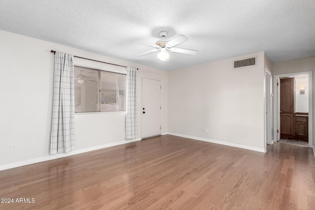 empty room featuring hardwood / wood-style floors, a textured ceiling, and ceiling fan