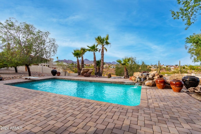 view of pool featuring a mountain view, pool water feature, and a patio area