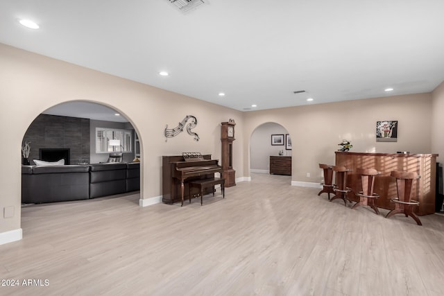 living room with light hardwood / wood-style floors and indoor bar