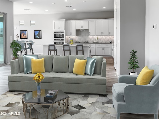 living room featuring sink, light hardwood / wood-style floors, and a healthy amount of sunlight