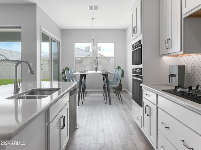 kitchen with sink, decorative light fixtures, a chandelier, white cabinetry, and dark hardwood / wood-style floors