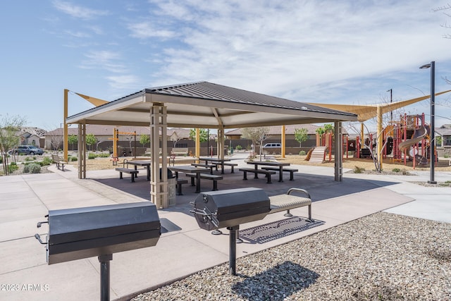 view of community featuring a playground, a gazebo, and a patio area