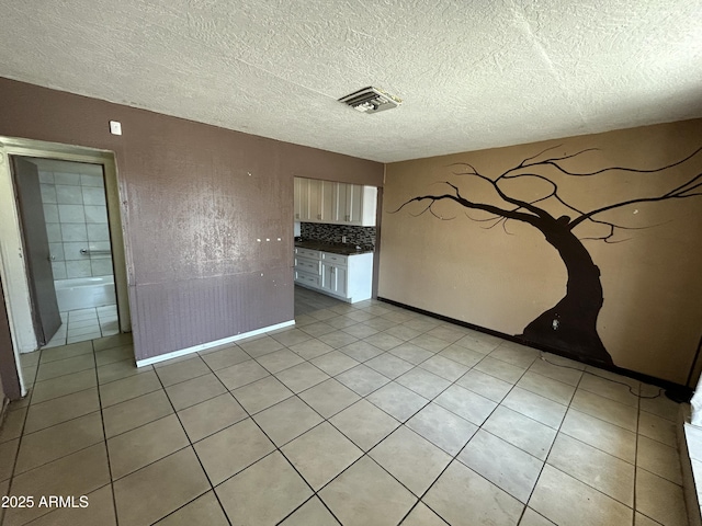 1816 N 38th Dr, Phoenix, AZ 85009 - empty room featuring light tile patterned floors, a textured ceiling, and baseboards