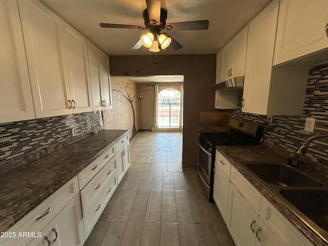 1816 N 38th Dr, Phoenix, AZ 85009 - kitchen with stainless steel gas range, a sink, tasteful backsplash, white cabinets, and under cabinet range hood