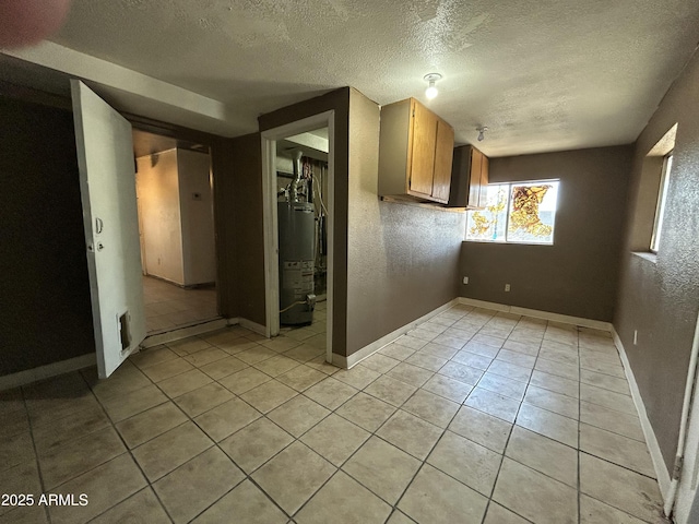 1816 N 38th Dr, Phoenix, AZ 85009 - empty room with water heater, a textured ceiling, light tile patterned floors, baseboards, and a textured wall