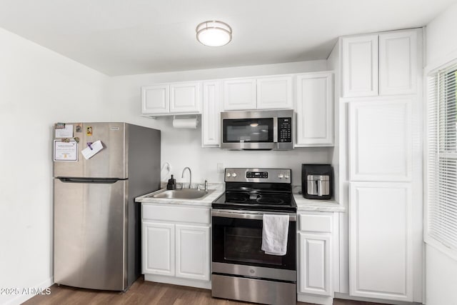 5044 N 18th Ave, Phoenix, AZ 85015 - kitchen featuring stainless steel appliances, light countertops, white cabinets, and wood finished floors