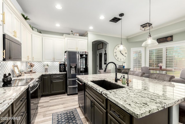 597 S 221st Dr, Buckeye, AZ 85326 - kitchen with a sink, black appliances, crown molding, white cabinets, and decorative backsplash