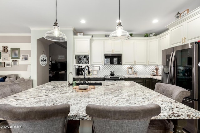 597 S 221st Dr, Buckeye, AZ 85326 - kitchen with appliances with stainless steel finishes, a sink, a kitchen breakfast bar, backsplash, and light stone countertops