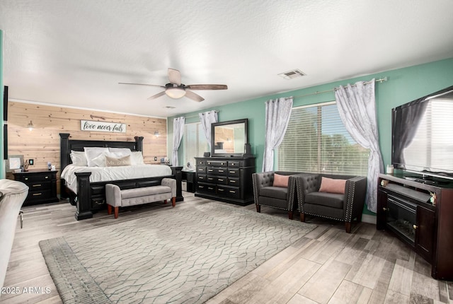 597 S 221st Dr, Buckeye, AZ 85326 - bedroom with multiple windows, light wood-style flooring, wooden walls, and a ceiling fan