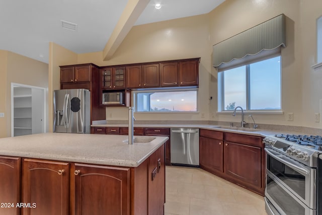 kitchen featuring beam ceiling, a kitchen island, sink, and appliances with stainless steel finishes