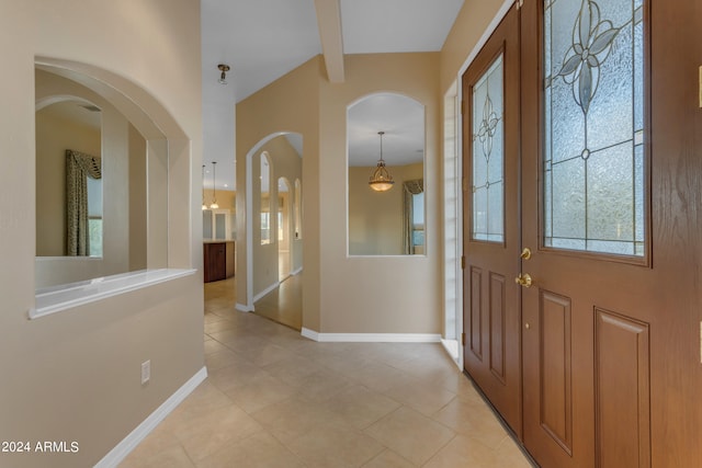 foyer featuring beam ceiling and light tile patterned floors