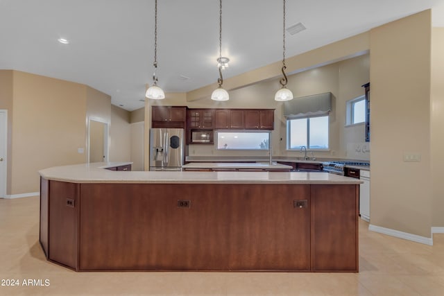 kitchen with stainless steel refrigerator with ice dispenser, a kitchen island, and pendant lighting