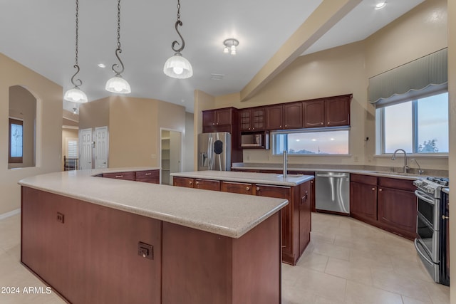 kitchen featuring sink, a kitchen island, stainless steel appliances, and decorative light fixtures