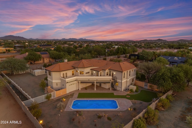 pool at dusk with a patio area