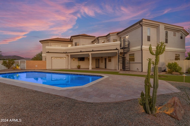 pool at dusk featuring a patio area