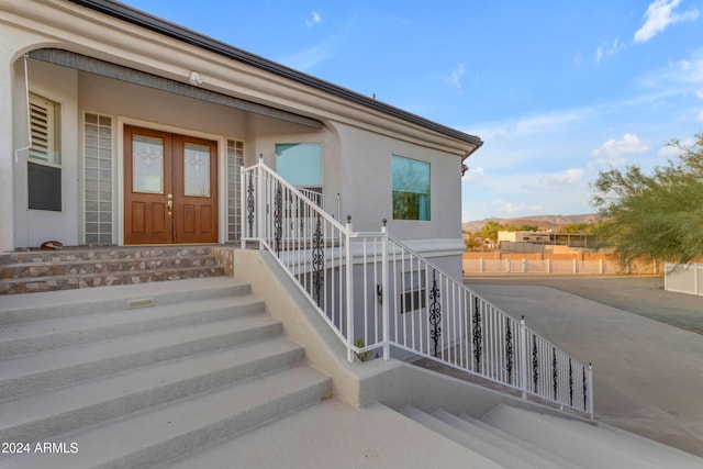 doorway to property featuring covered porch and french doors