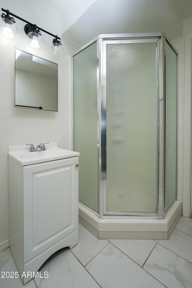 full bath featuring marble finish floor, vanity, and a shower stall