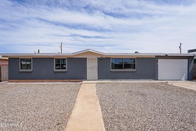 ranch-style house featuring driveway, brick siding, and a garage
