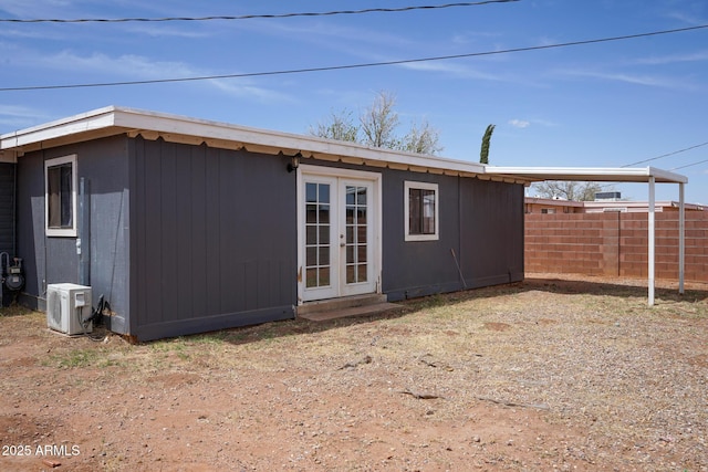 rear view of property featuring ac unit, fence, and french doors